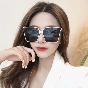 Moderne quadratische Übergröße-Sonnenbrille mit weißem Rahmen an einem Model präsentiert