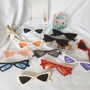 Présentation à plat de lunettes de soleil œil de chat rétro en plusieurs couleurs sur tissu