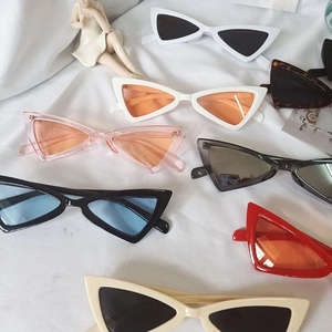 Vue à plat de lunettes de soleil œil de chat rétro en plusieurs couleurs sur tissu blanc