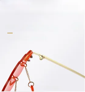 Close-up of frameless cloud sunglasses featuring delicate metal hinges and orange lenses