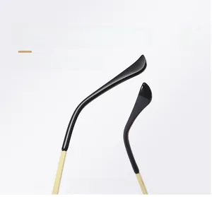 Detail of ergonomic curved golden metal sunglasses temple with black tip covers