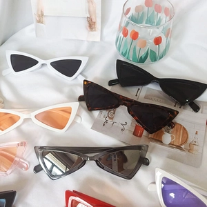 Lunettes de soleil œil de chat triangulaires Y2K en couleurs variées sur tissu blanc