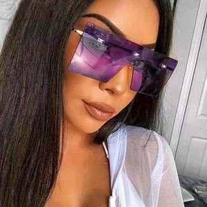 Close-up of oversized rimless square sunglasses with purple gradient lenses and metal arms