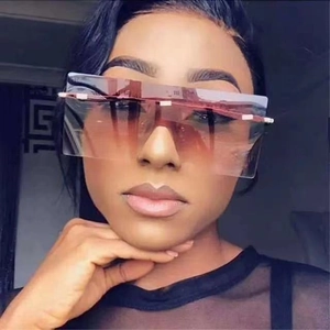 Close-up of oversized rimless square sunglasses with brown gradient lenses and metal hinges