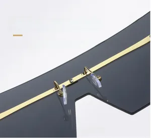 Macro detail of golden metal bridge and soft silicone nose pads on oversized sunglasses