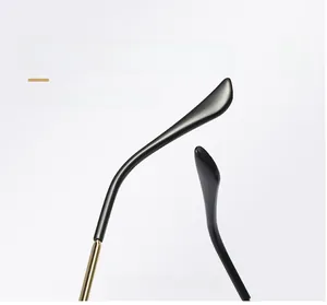 Detail of sleek golden metal curved mirror legs with black tips for square sunglasses