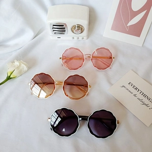 Kids vintage wavy flower frame sunglasses in pink and tan colors on white background