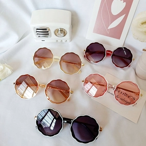 Flat lay of retro flower frame kids sunglasses in assorted colors on white cloth
