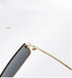 Detailed close-up of delicate golden metal frame and sleek dark grey lenses for sunglasses