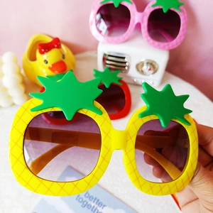 Detail of pineapple and strawberry fruit shaped sunglasses for kids with colorful plastic frames