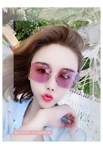 Close-up of rimless square sunglasses with pink gradient lenses and gold metal temples
