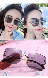 Close-up of golden C-shaped metal hinge and gradient lenses on rimless sunglasses