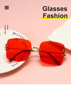 Close-up of red rimless square sunglasses with gold metal bridge on ceramic display