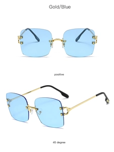 Detail view of rimless square sunglasses with blue lenses and gold metal temples