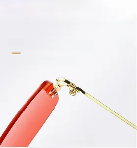 Close-up of delicate gold metal frame hinges and red translucent sunglass lenses