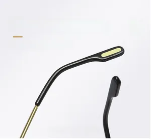 Detail of curved eyeglass temples with ergonomic black tips and yellow decorative accents