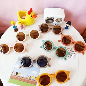 Flat lay of colorful round frame children's sunglasses with matte finish and UV protection