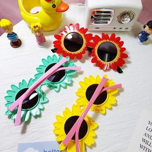 Close-up of sunflower shaped kids sunglasses in vibrant red, green, and yellow finishes
