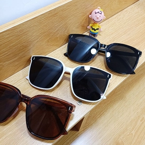 Classic square frame sunglasses in black, white, and tortoiseshell on a wooden surface