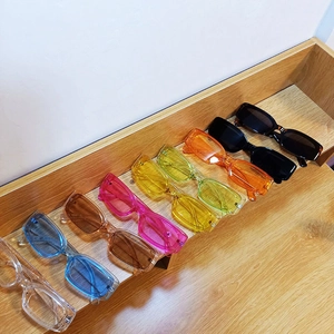 Close-up of colorful rectangle sunglasses in various transparent candy colors on display