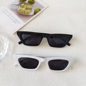 Flat lay of vintage cat eye sunglasses in black and white frames on white background