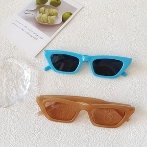 Retro cat-eye sunglasses in blue and translucent brown on a textured white background