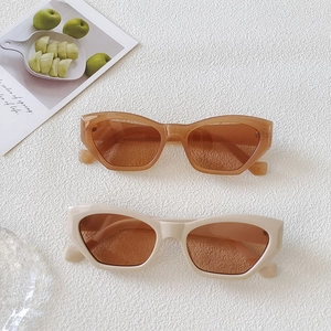 Retro small frame cat-eye sunglasses in amber and cream beige with dark lenses