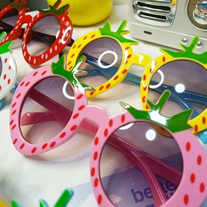 Detailansicht der bunten Erdbeer-Kinder-Sonnenbrillen mit Pünktchen und Blatt-Design