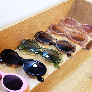 Detail view of colorful retro Y2K oval sunglasses in multiple candy colors and prints