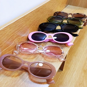 Retro oval sunglasses in various candy colors shown on a wooden background