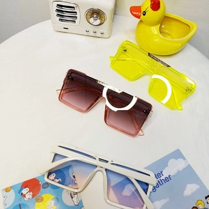 Detailed view of square stylish children's sunglasses in yellow, brown and white frames