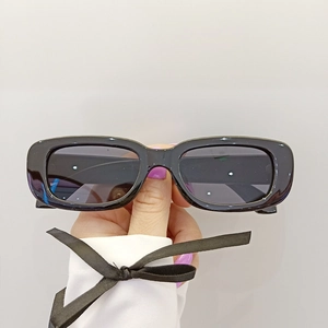 Gros plan de lunettes de soleil rectangulaires rétro pour enfants avec monture noire épaisse
