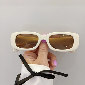 Détail de lunettes de soleil rétro pour enfants avec monture blanche et verres ambrés