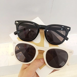 Retro oversized sunglasses in black and cream beige with metallic rivets and UV protection
