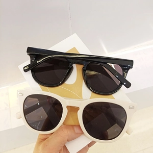 Retro UV protection sunglasses with black and cream frames and classic stud accents