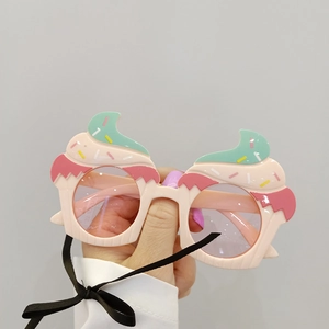 Dettaglio degli occhiali da festa a forma di cupcake nei colori verde menta e rosa