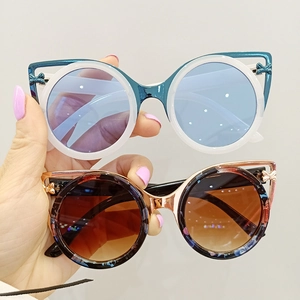 Fashionable round sunglasses for kids with metal frames and cute bow details on pure gray