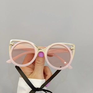 Detail of pink round sunglasses with gold cat-eye frame and bow-knot accent on temples