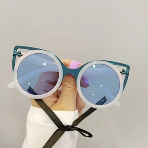 Detailed view of dual-layer cat-eye sunglasses with bow accents and blue lenses