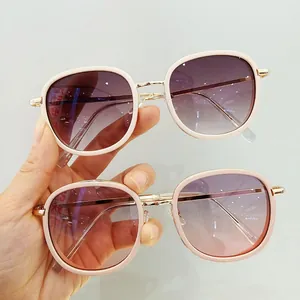 Detail showing vintage oversized kids sunglasses with beige frames and gradient lenses