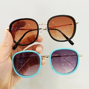 Detail view of large frame sunglasses with gradient lenses and gold bridge for children
