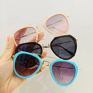Close-up of three pilot-style kids' sunglasses with metal frames and gradient lenses