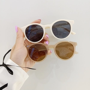 Retro-Kinder-Sonnenbrille mit rundem Rahmen in Weiß und Rosa für Strand und Urlaub