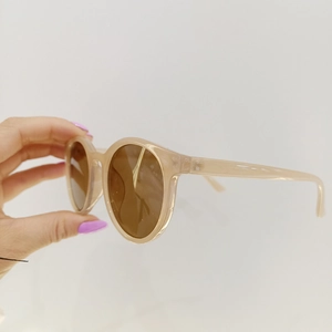 Detail der runden Kinder-Sonnenbrille in Geleebraun mit durchsichtigem Gestell