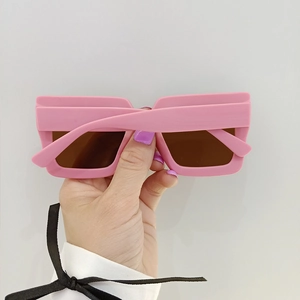 Detail of pink rectangular kids sunglasses with thick frames and dark brown lenses