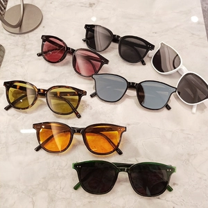 Multiple colors of retro oversized square sunglasses on marble surface with metal rivets