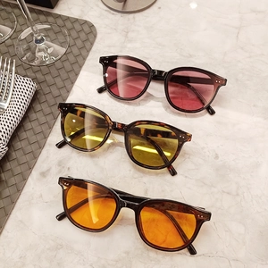Detailed view of colorful large frame sunglasses with metal dots on a marble surface