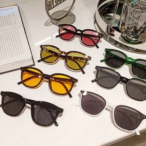 Flat lay of multiple stylish oversized sunglasses in assorted colors on marble background