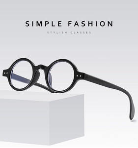 Detail of black round frame glasses with vintage minimalist design and rivet accents