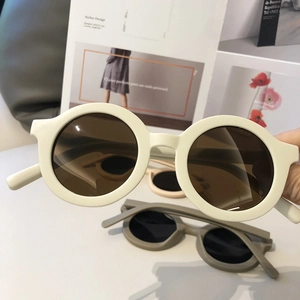 Detail view of cream and cement gray retro round sunglasses with thick frames and tinted lenses